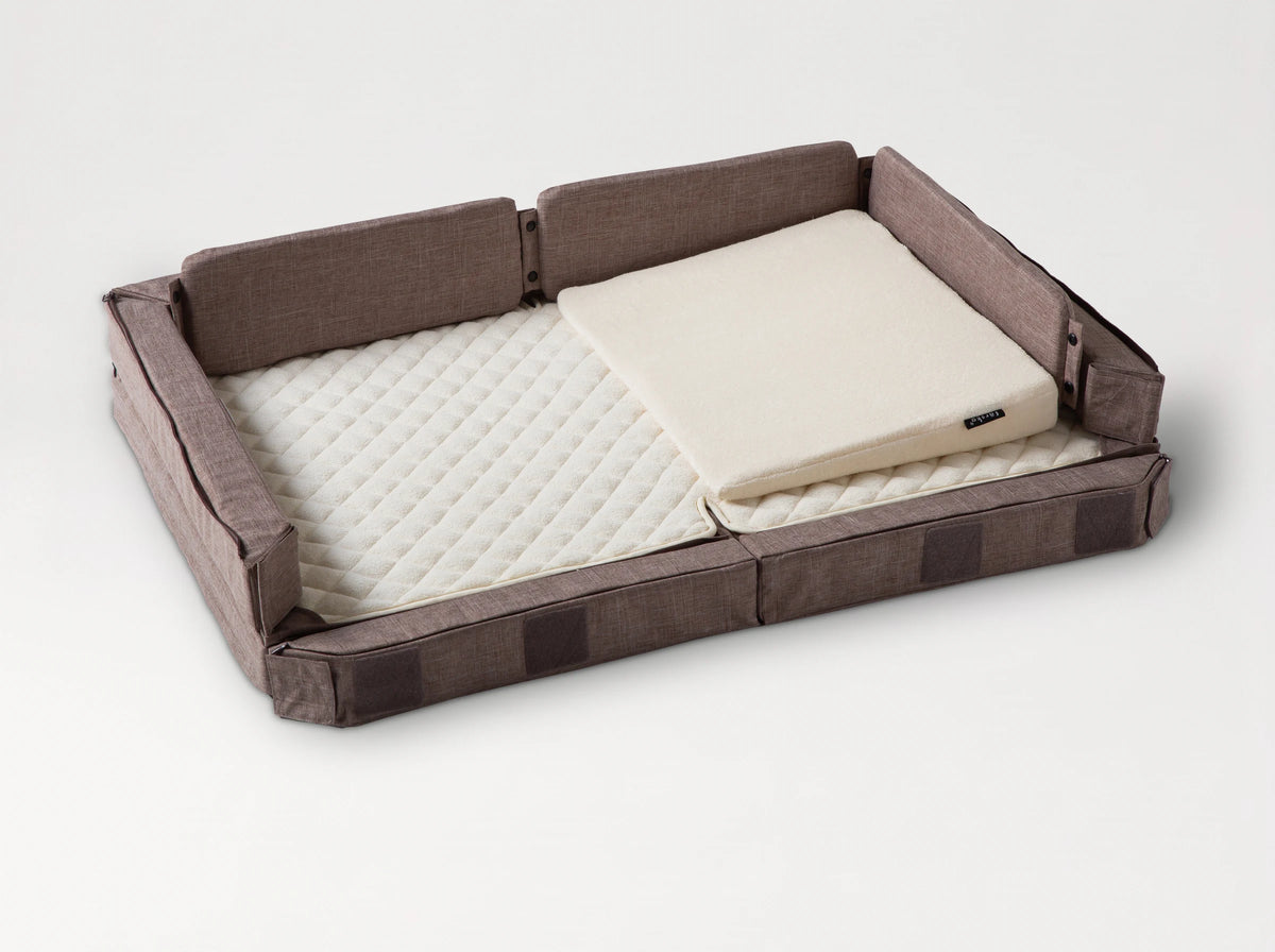 Compact Bed Free in Melange Brown in co-sleeping mode: the front side lowered to the mattress, the wedge pillow in place