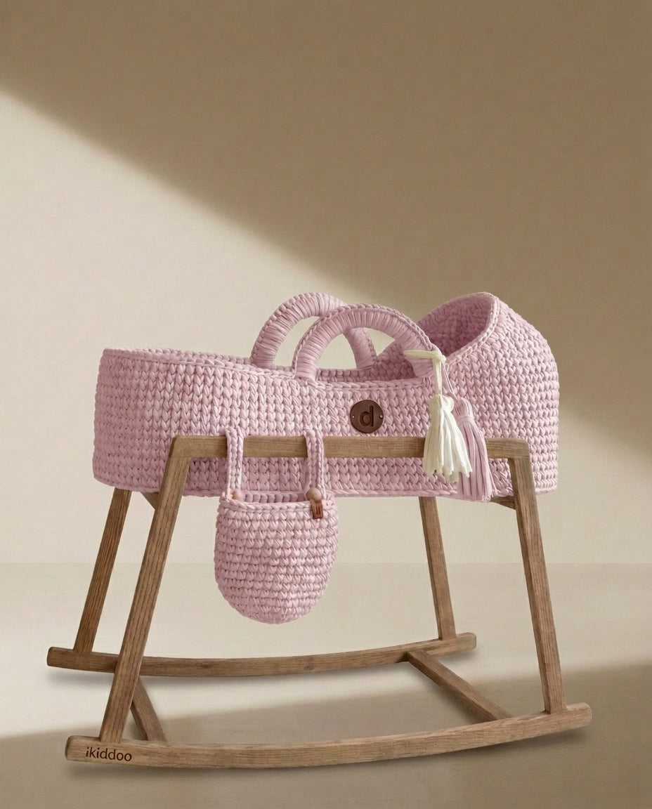 Pink handwoven Moses basket on the wooden rocking stand