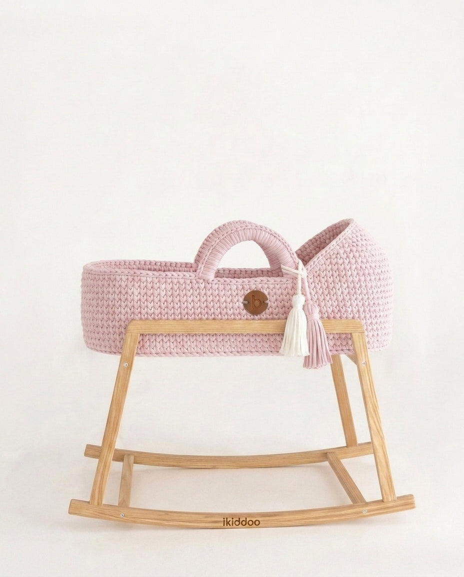 Pink handwoven Moses basket, side view on the wooden stand
