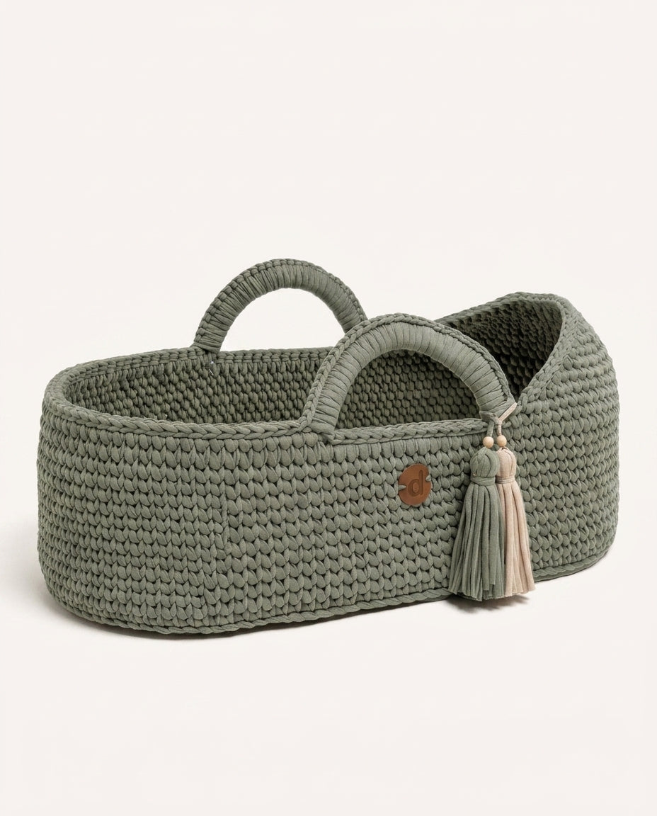 Sage handwoven Moses basket on a soft neutral background