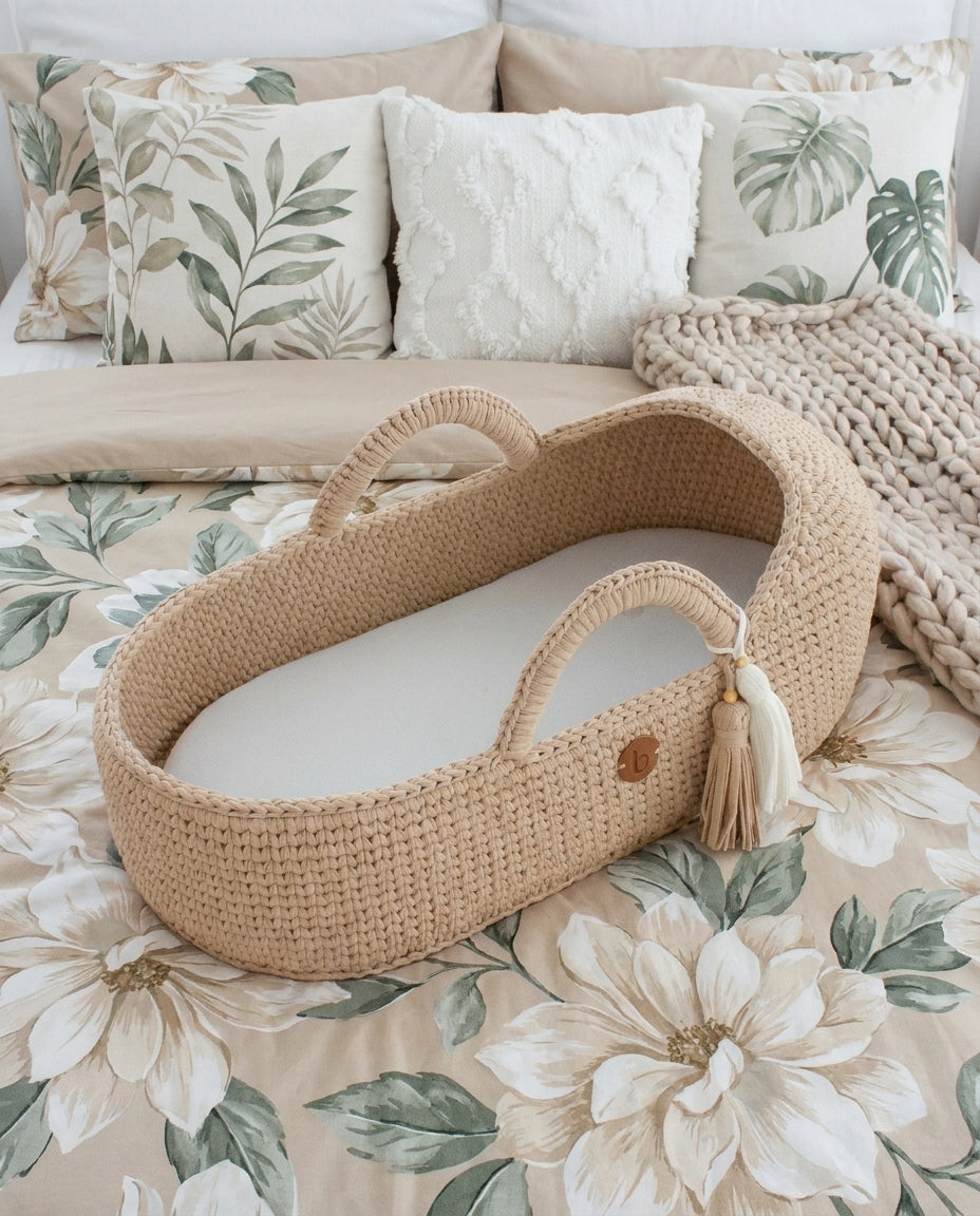 Handwoven Moses basket with the mattress visible on a floral bed