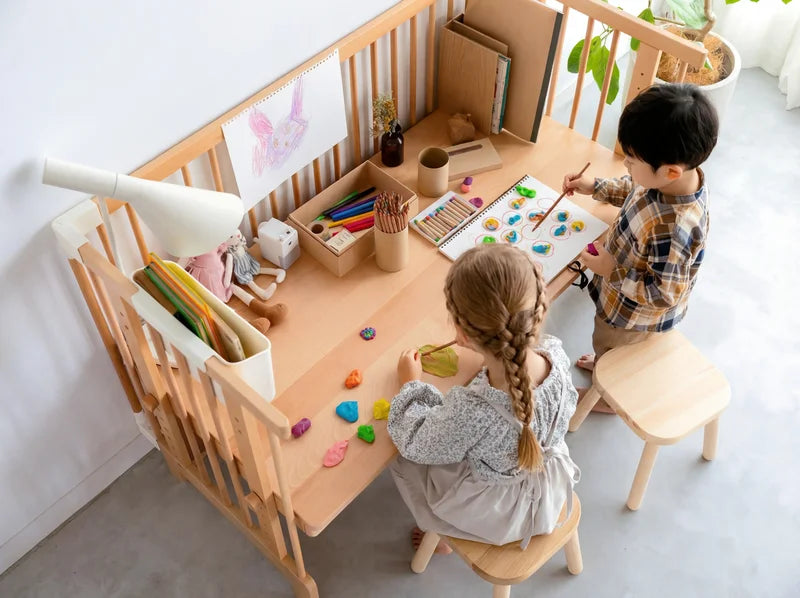 Two children doing crafts at the Creative Cot Long kids' table