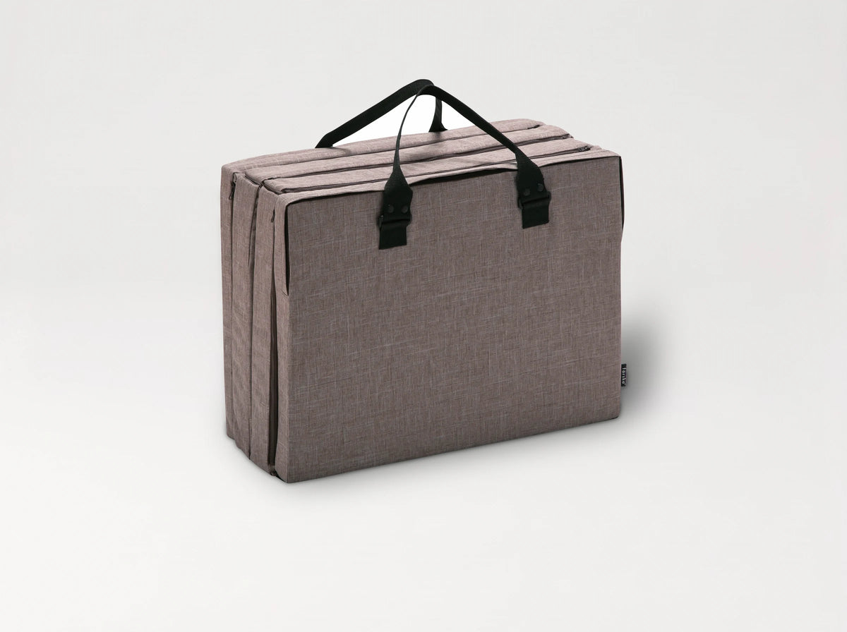 The Compact Bed Free in Melange Brown folded into its carry bag with handles 