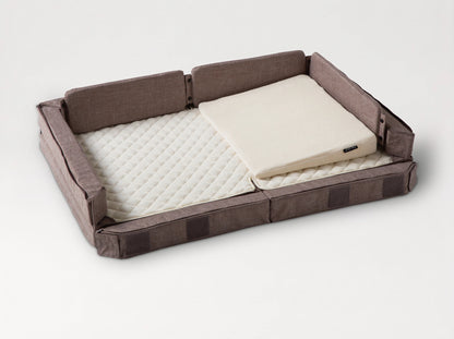 Compact Bed Free in Melange Brown in co-sleeping mode: the front side lowered to the mattress, the wedge pillow in place 