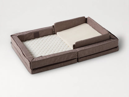 Compact Bed Free in Melange Brown in safety mode: padded sides raised all round the quilted mattress, with the wedge pillow 