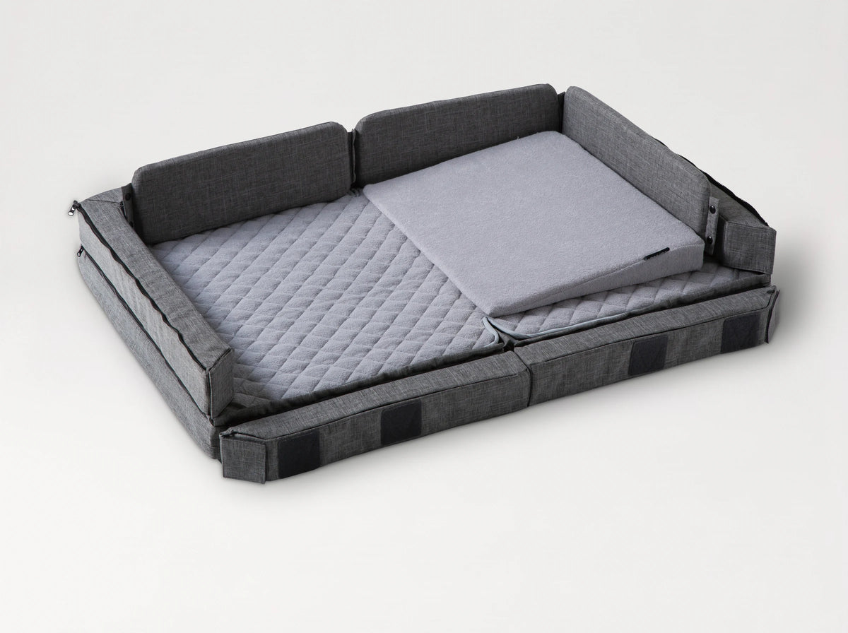 Compact Bed Free in Melange Gray in co-sleeping mode: the front side lowered to the mattress, the wedge pillow in place 