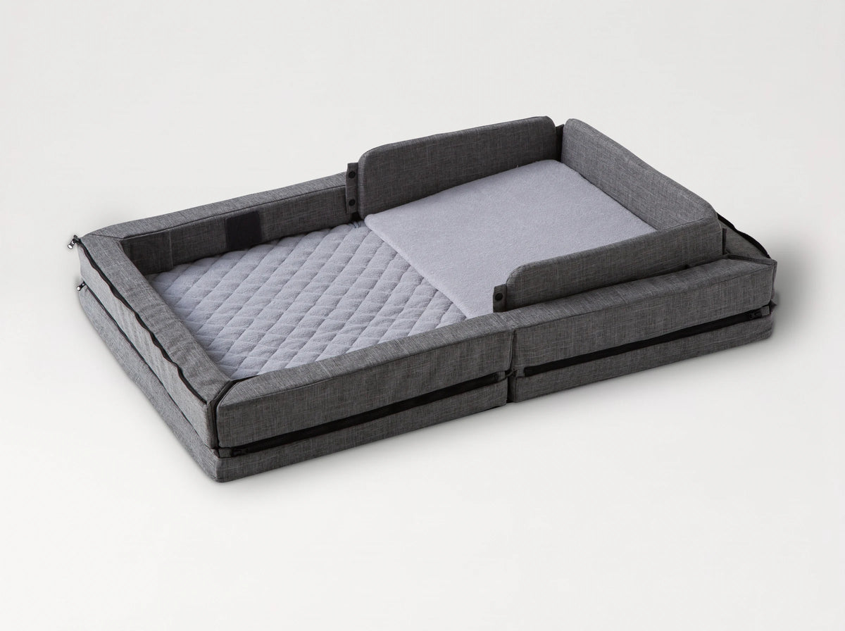 Compact Bed Free in Melange Gray in safety mode: padded sides raised all round the quilted mattress, with the wedge pillow 
