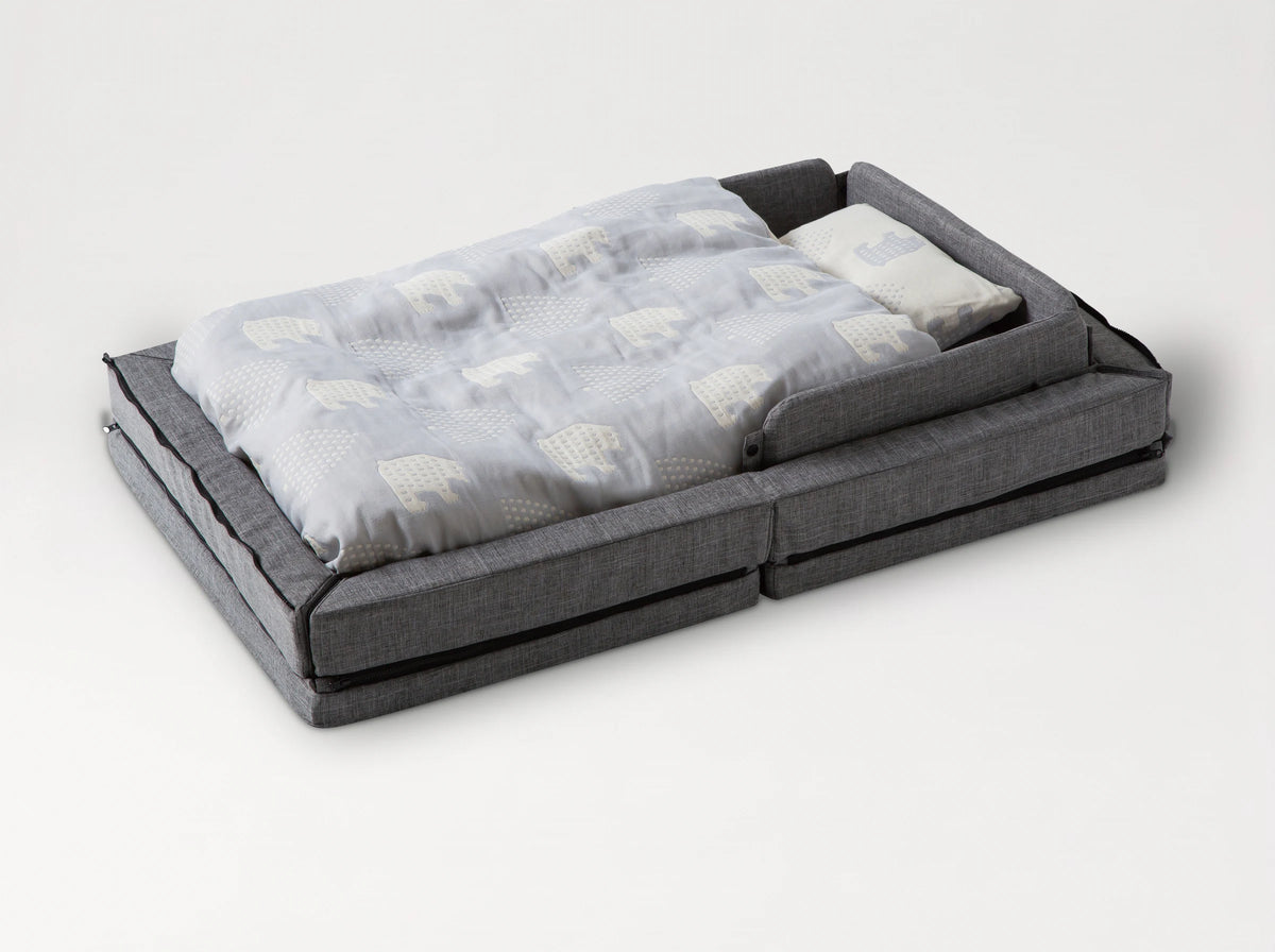 The färska Compact Bed Free in Melange Gray, made up with its quilt and pillow, sides raised #color_melange-gray