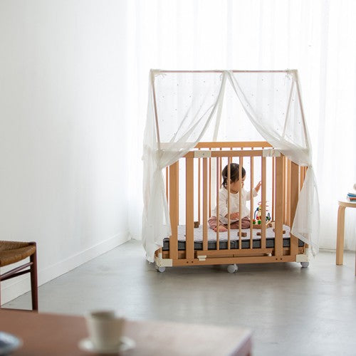 Child playing inside the Creative Cot under the farska Canopy