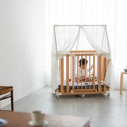 Child playing inside a Creative Cot under the farska Canopy