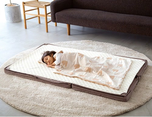 Child asleep on two Joint Mattresses zipped together in Melange Brown
