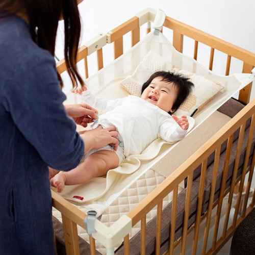 Baby having a nappy change on the Multi Net stretched across the Creative Cot