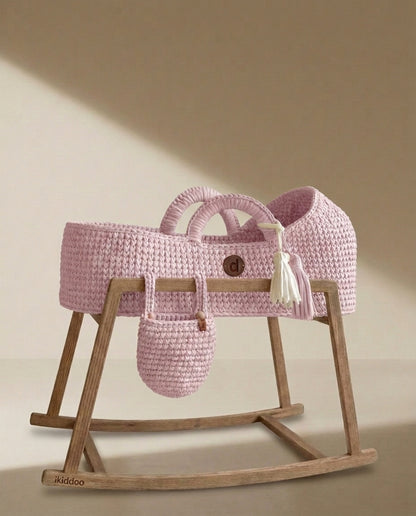 Pink handwoven Moses basket on the wooden rocking stand