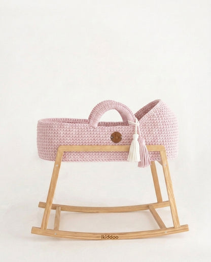 Pink handwoven Moses basket, side view on the wooden stand