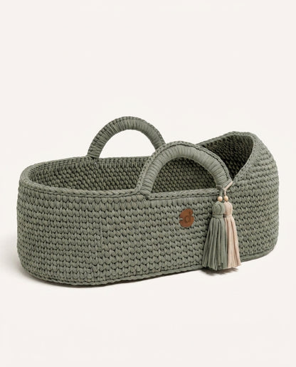 Sage handwoven Moses basket on a soft neutral background