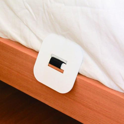 Steel anchor plate tucked under the edge of an adult mattress