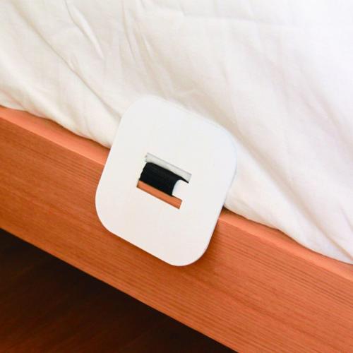 Steel anchor plate tucked under the edge of an adult mattress
