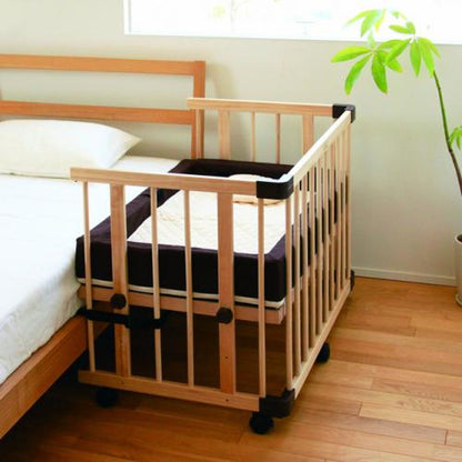 Cot standing tight against the parent bed with the belt fitted
