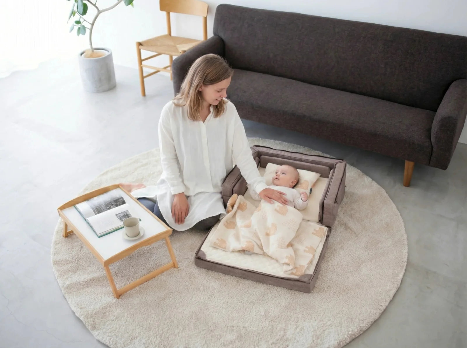 A baby sleeping peacefully in the Compact Bed Free beside mum at home