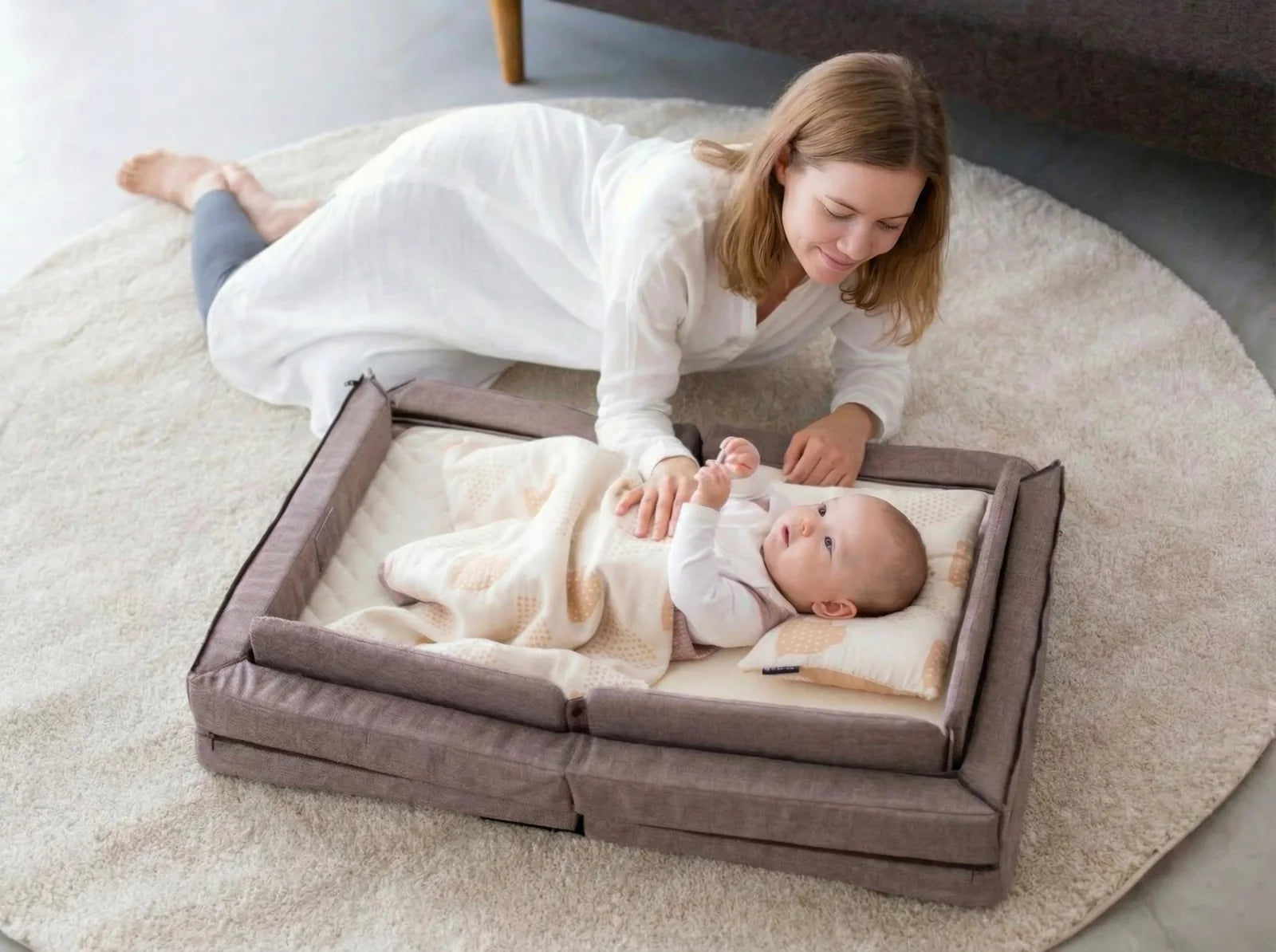 A mother beside her baby resting peacefully in the Compact Bed Free