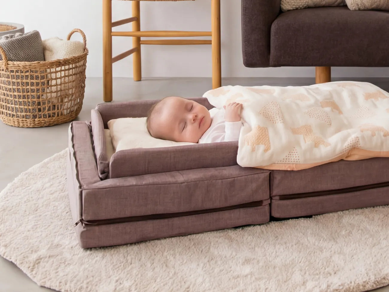 A baby sleeping safely in the Compact Bed Free with raised bumpers