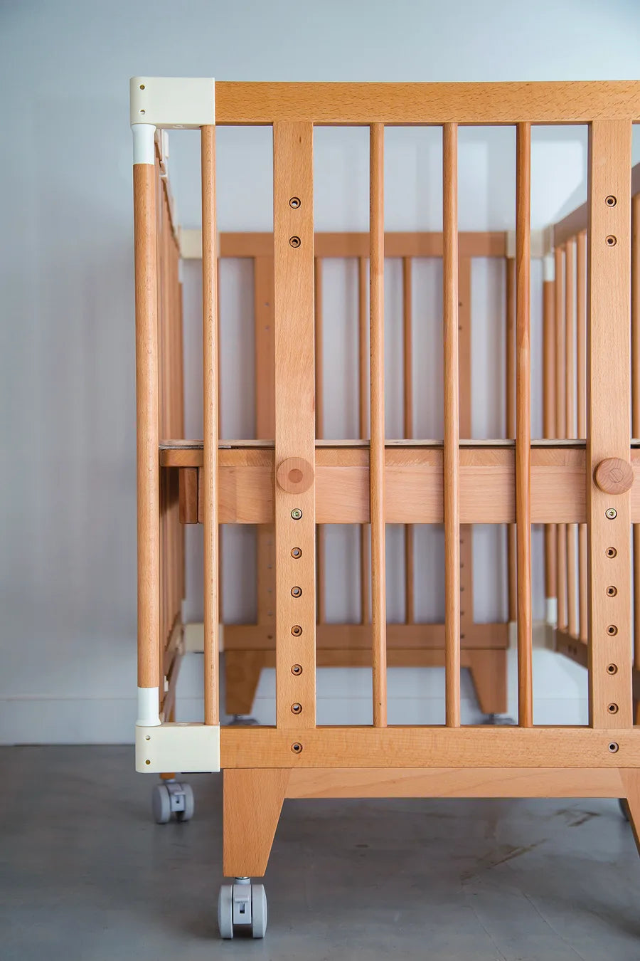 Rows of height-adjustment holes on the side frame of the Creative Cot