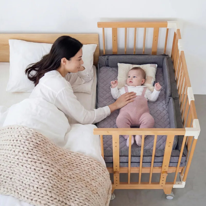 A mother beside her baby in the Creative Cot