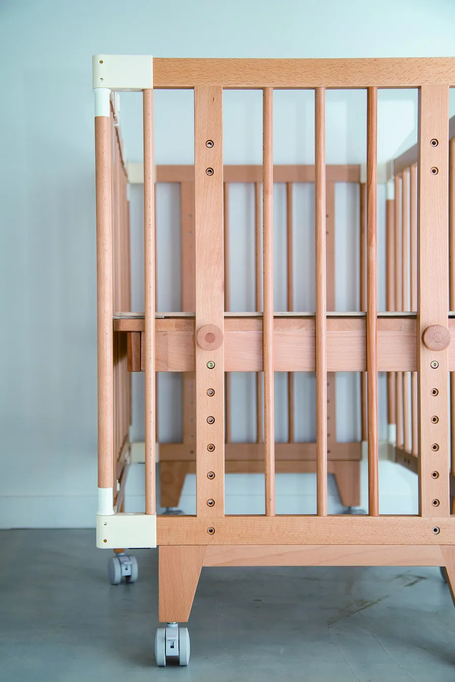 Rows of height-adjustment holes on the side frame of the Creative Cot Long
