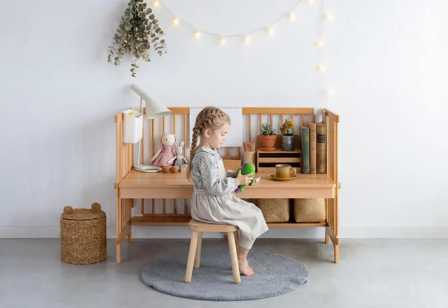 The Creative Cot Long in study desk mode - panels rearranged, child seated at the desk