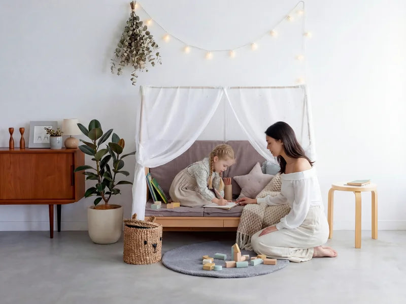 Mum reading with her daughter on the Creative Cot Long sofa with a canopy
