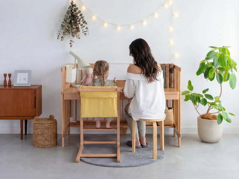 A child doing homework at the Creative Cot Long study desk, mom sitting beside them